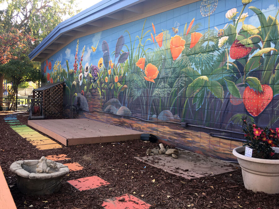 Flower mural of California Poppies, Strawberries, Foxgloves, and Pansies at a School