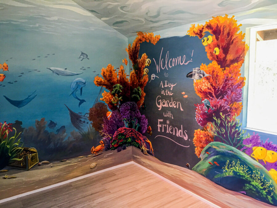 Colorful Coral Mural Painting with Dolphins, Sunken Ship, and Treasure Chest
